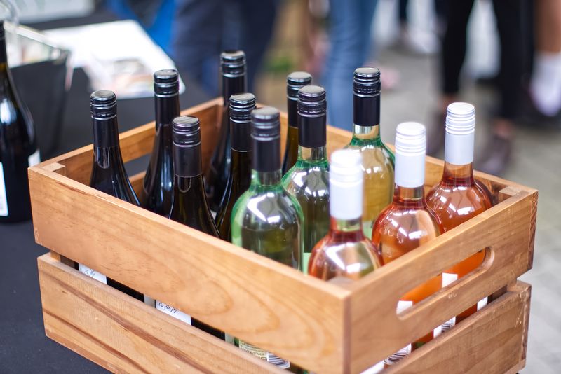 Crate of white and rose bottles at a market stall — photo by Mark Thomas on Pexels