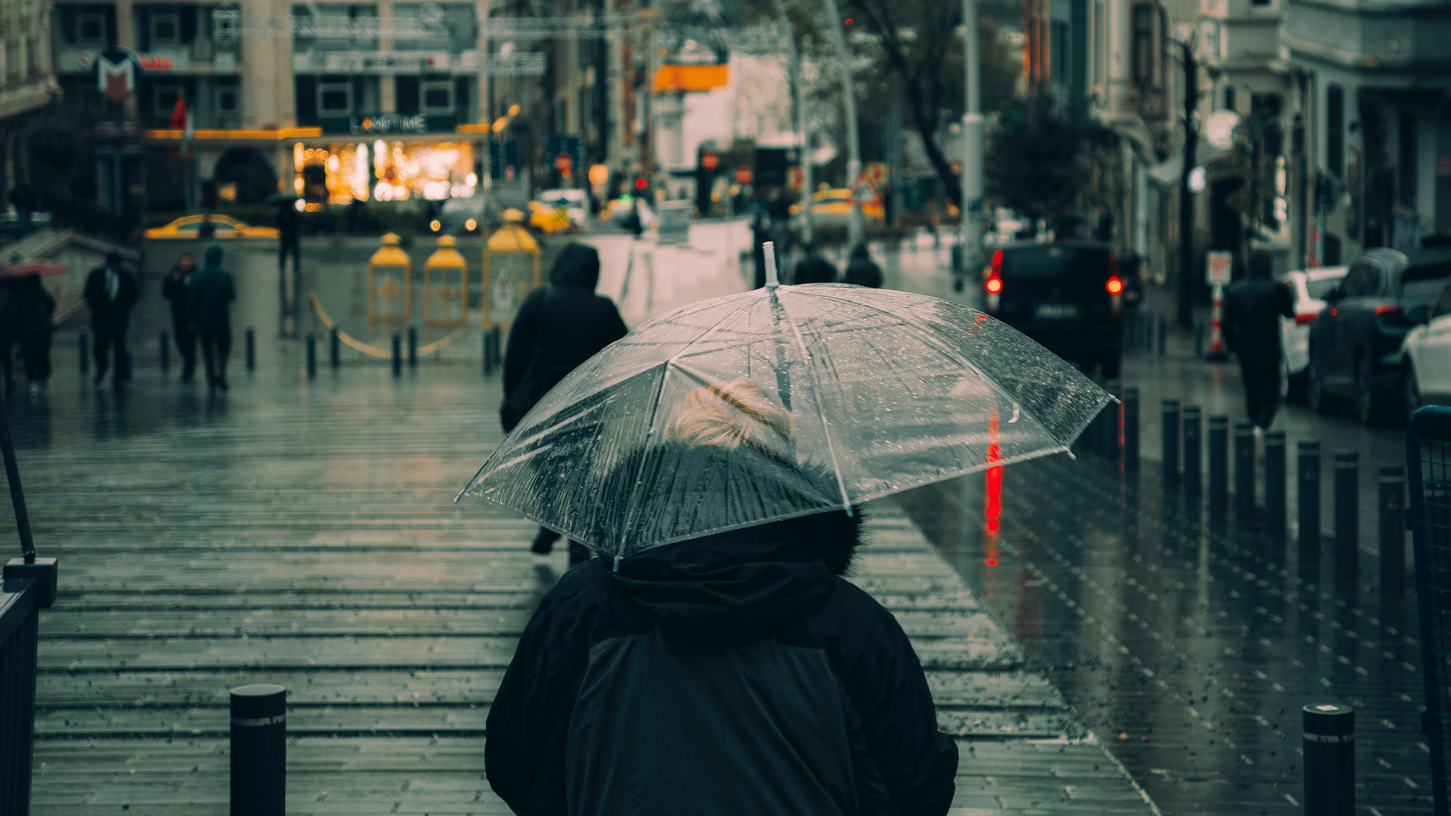 Athens rainy day activities indoor - person walking under umbrella on a rainy city street