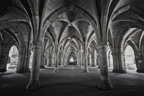 Free Monochrome view of the Gothic cloisters showcasing stunning arches and symmetry at the University of Glasgow, Scotland. Stock Photo