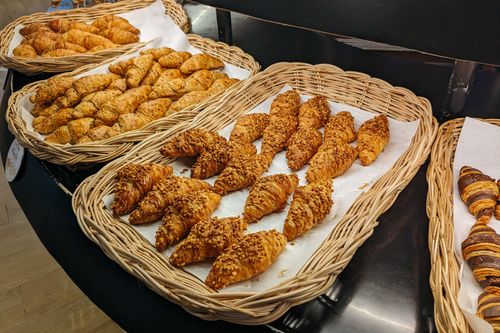 Free An assortment of fresh croissants displayed in wicker baskets at a bakery. Stock Photo
