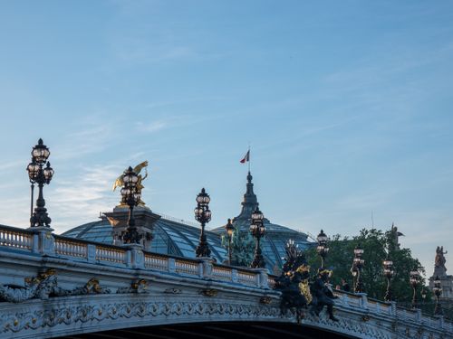 Free View of the ornate Pont Alexandre III and Grand Palais against a clear blue Parisian sky. Stock Photo