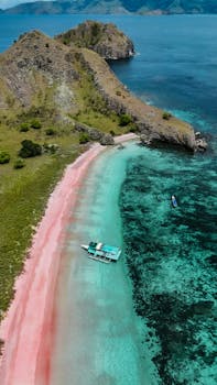 Aerial view of a mesmerizing pink sand beach in East Nusa Tenggara, Indonesia, surrounded by turquoise waters.