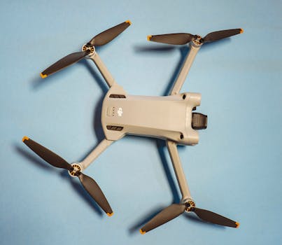 Modern drone with propellers displayed on a minimalist blue background, showcasing technology.