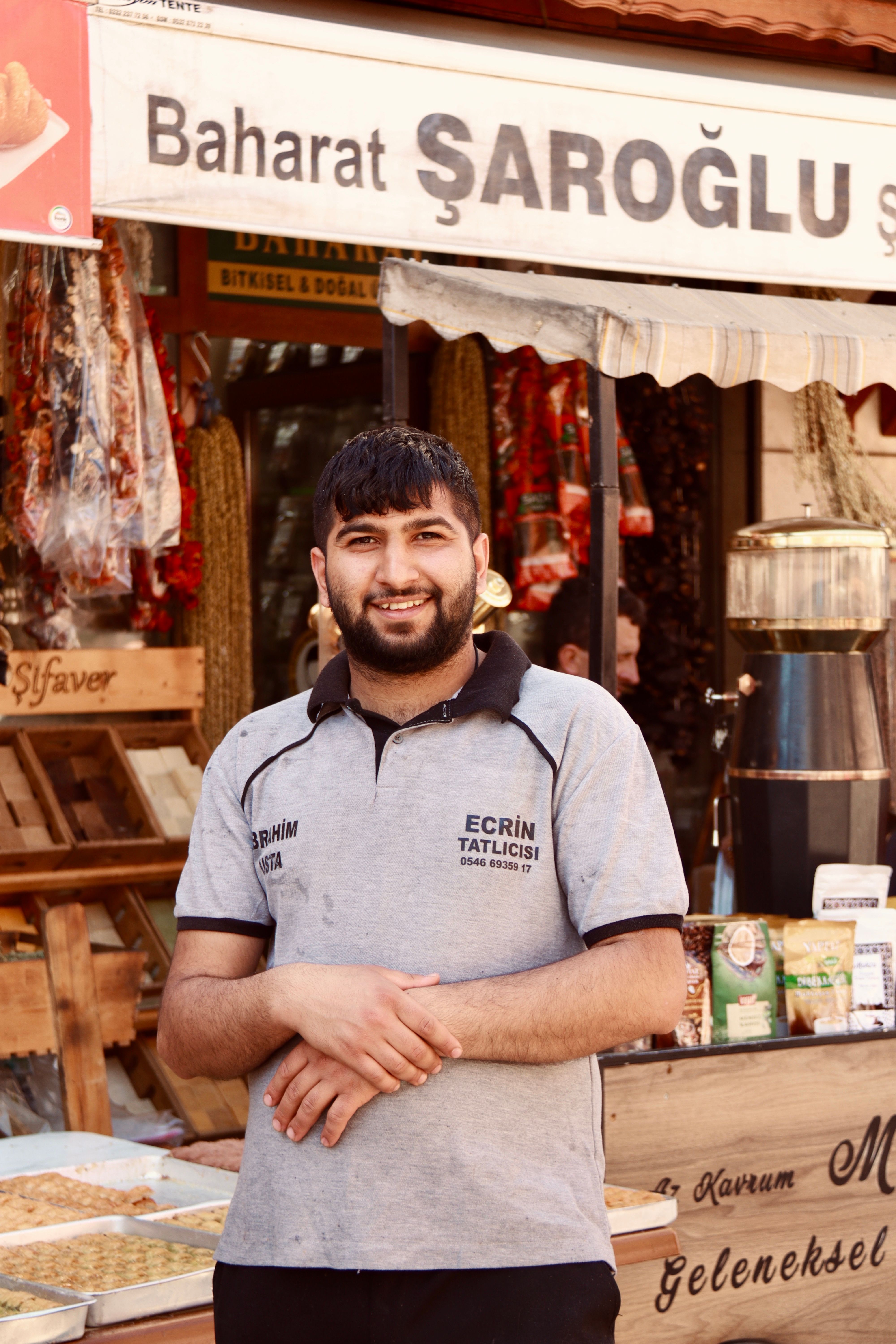 Portrait of a local vendor outside a traditional spice shop in Konya, Türkiye, showcasing local culture.