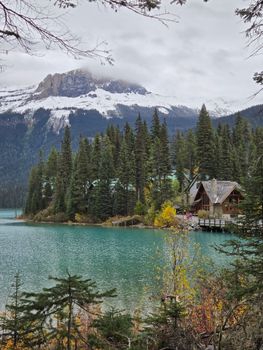 Picturesque lodge by Emerald Lake with snowy mountains and pine trees.