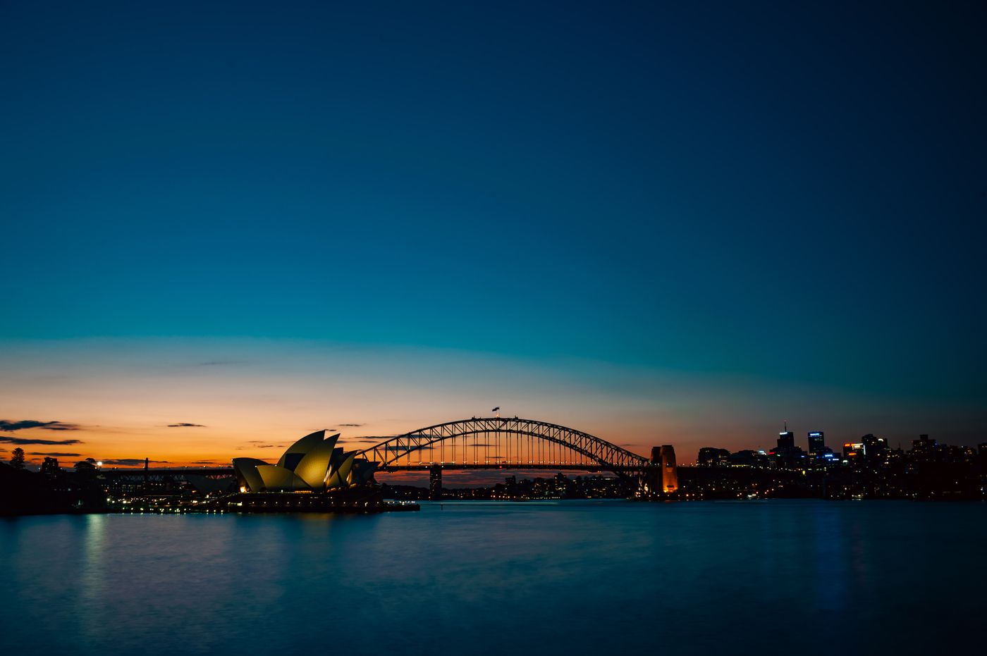 Sydney Harbour Bridge arching over the water at dusk