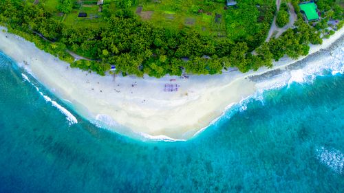 Free A breathtaking aerial view of a tropical island beach with lush greenery and turquoise waters. Stock Photo