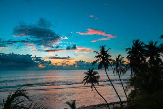 Serene sunset view with palm trees silhouetted against the colorful sky in Fuvahmulah, Maldives.