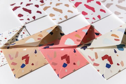 Free Flat lay of colorful terrazzo-patterned envelopes in natural light. Stock Photo