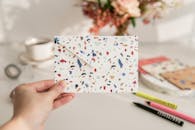 Hand Holding Terrazzo Patterned Envelope