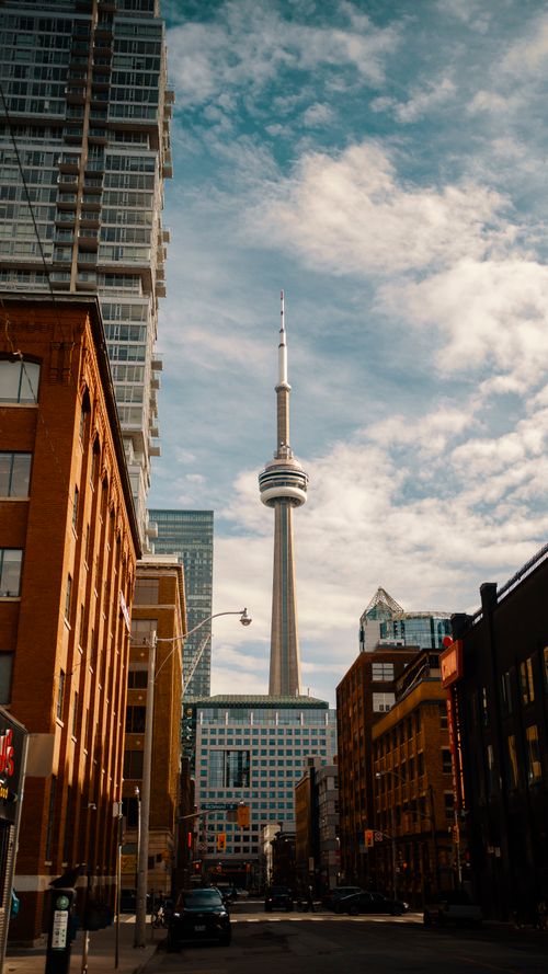 Free A vibrant view of downtown Toronto with the iconic CN Tower under a blue sky. Stock Photo