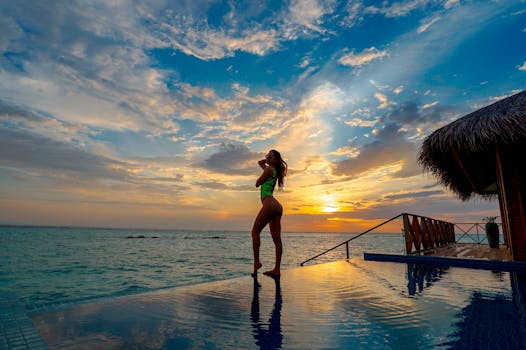 一位女士在马尔代夫的豪华度假胜地，欣赏着令人惊叹的日落美景，尽显优雅与宁静