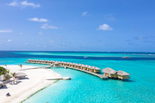 Free Stunning beachfront resort with overwater bungalows and turquoise waters, perfect for a summer vacation. Stock Photo
