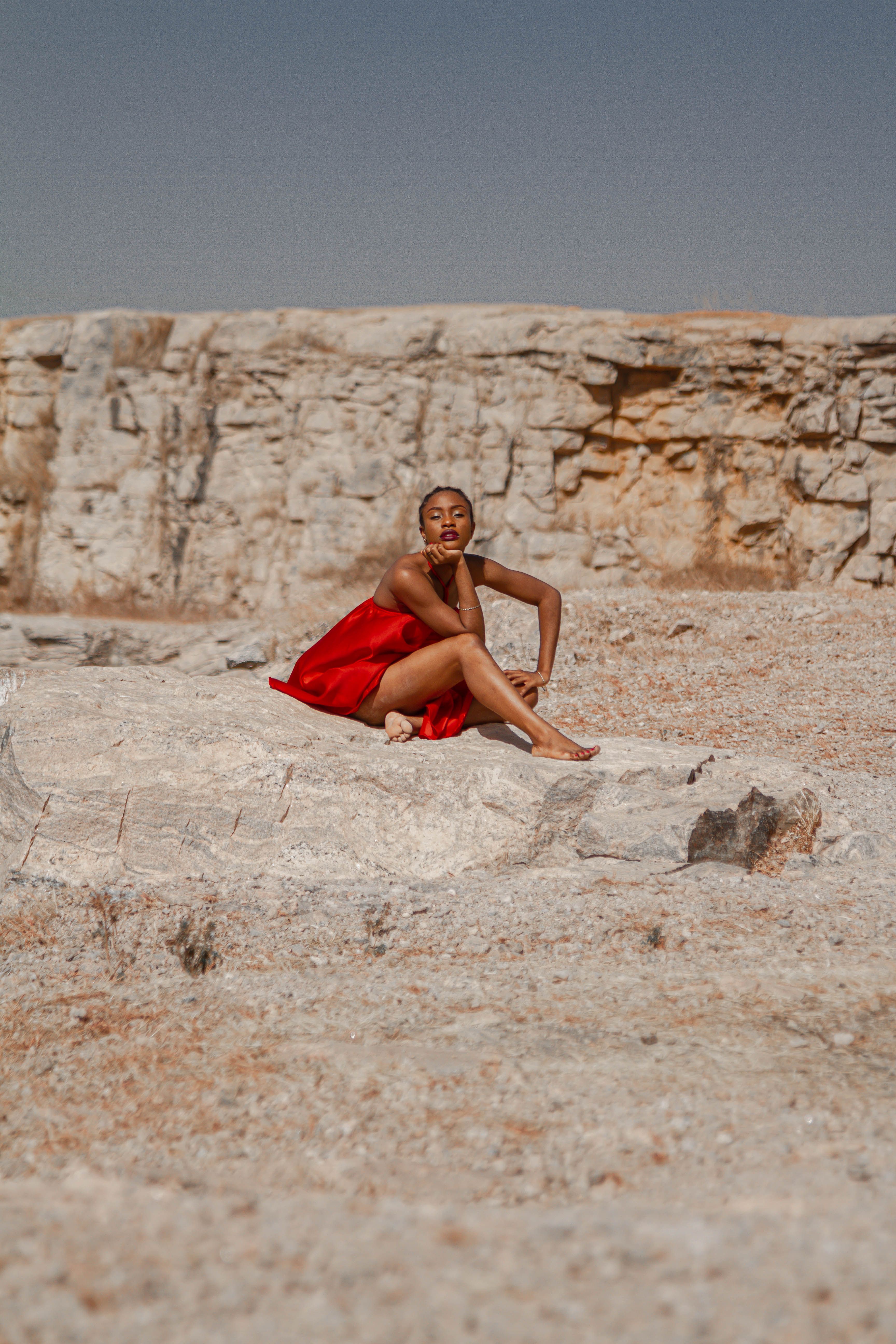 Elegant Woman in Red Dress on Rocky Terrain · Free Stock Photo