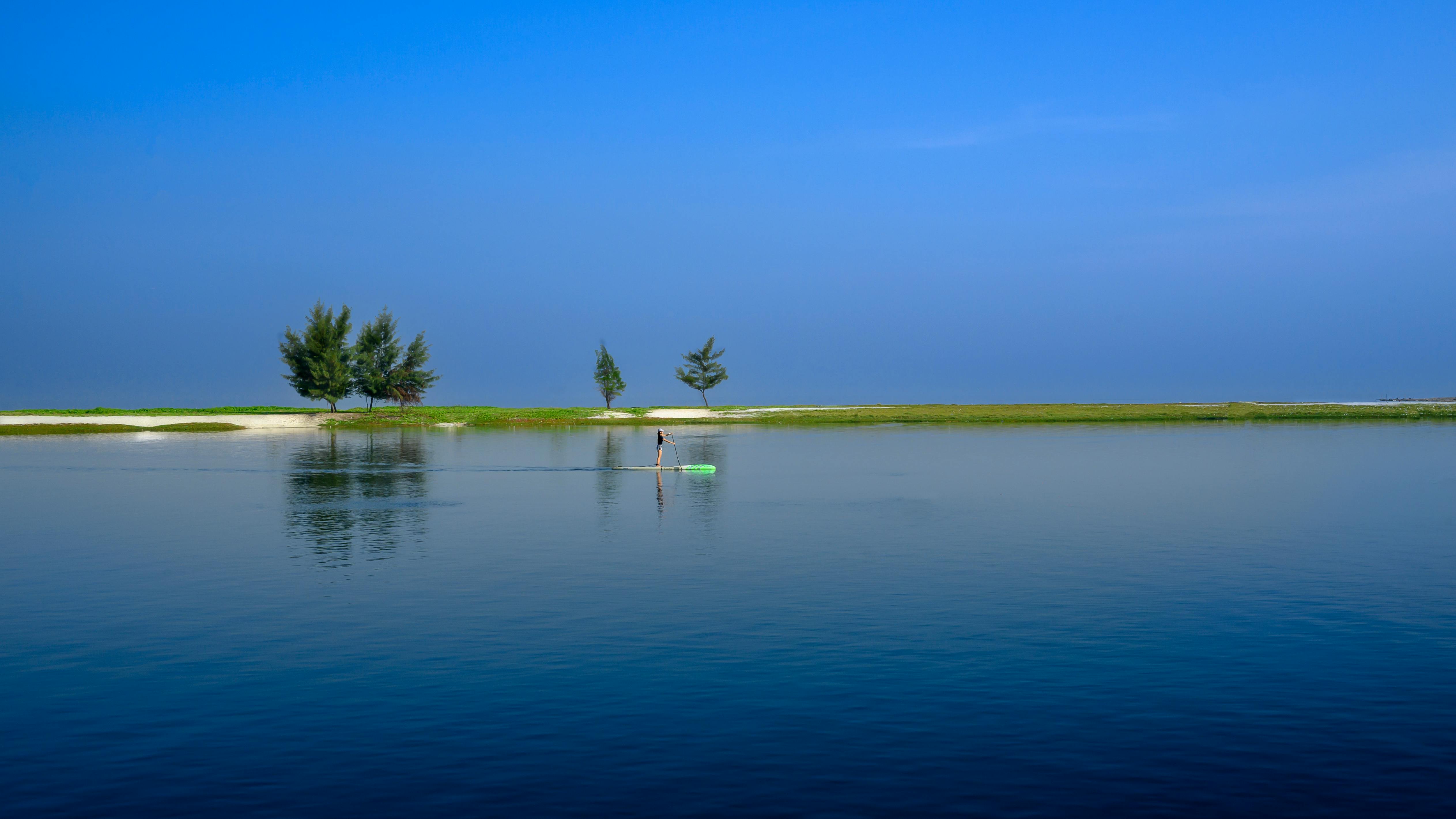 Miễn phí Cảnh tượng yên bình của một người đang chèo thuyền trên mặt nước phẳng lặng với bầu trời trong xanh ở Jakarta, Indonesia. Ảnh lưu trữ