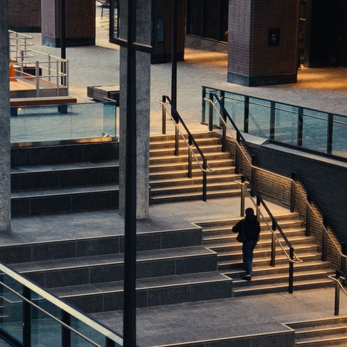 Free A person ascends a modern staircase in an urban building in Toronto, Canada. Stock Photo