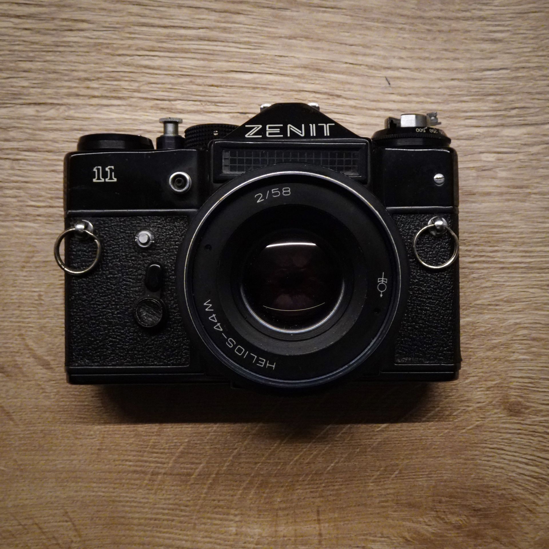 Top view of a classic Zenit 11 camera with Helios lens on wooden background.