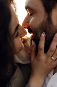 Intimate moment captured between a couple embracing closely during sunset, highlighting love and connection.