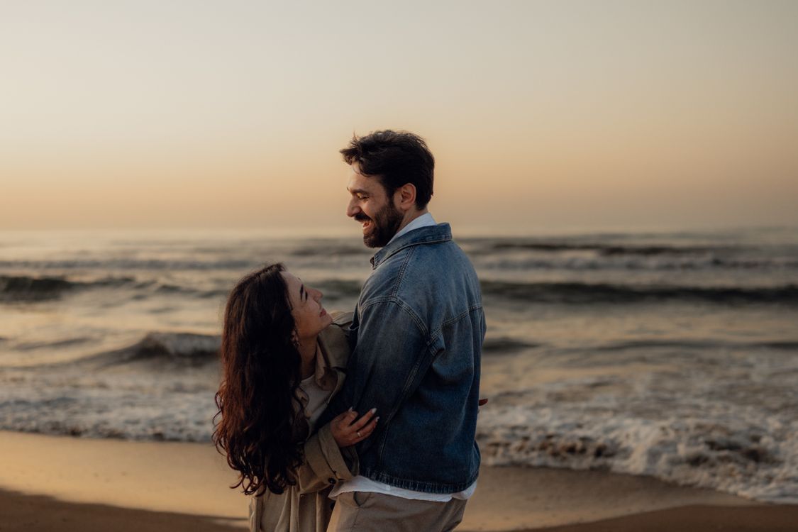 Romantic Couple Embracing at Sunset Beach · Free Stock Photo