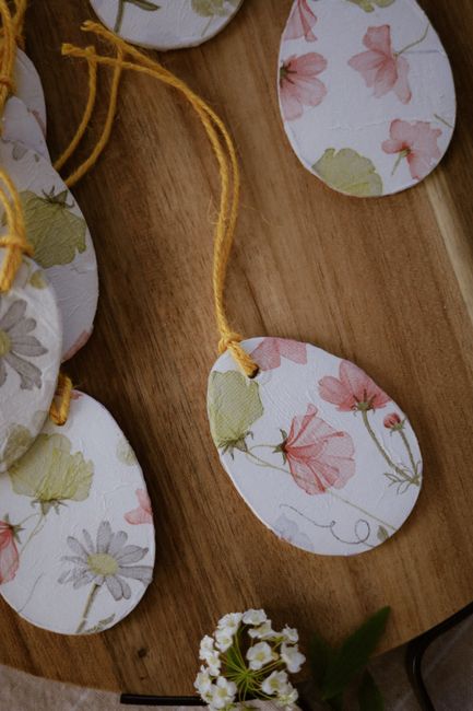 Beautiful floral pattern wooden tags with yellow string on a wooden surface.