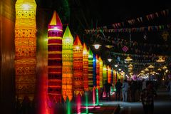 A lively festival scene with vibrant lanterns and decorations illuminated at night, creating a festive atmosphere.
