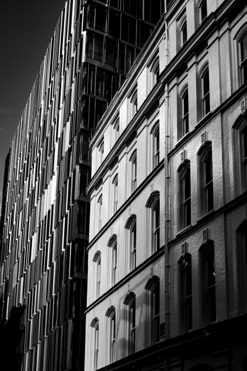Free Black and white photo showcasing classic and modern building architecture. Stock Photo