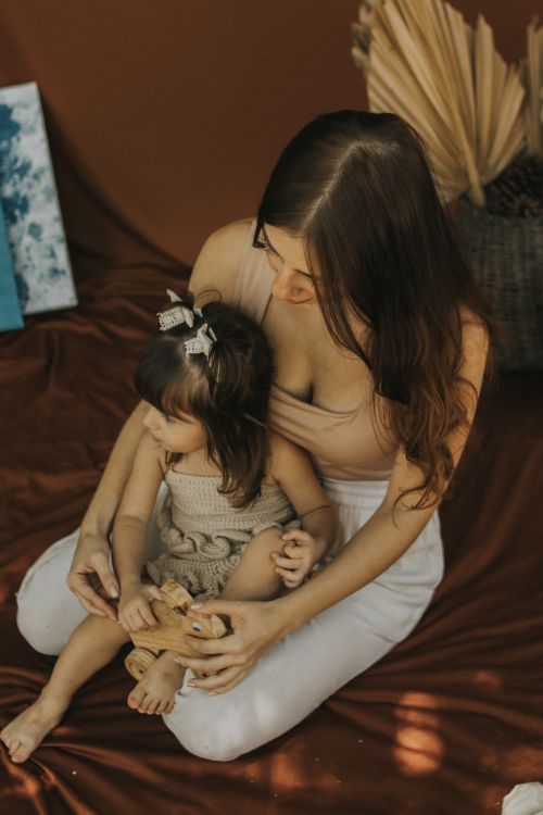 Free Warm indoor scene of a mother and child sharing a moment with teddy bear. Stock Photo