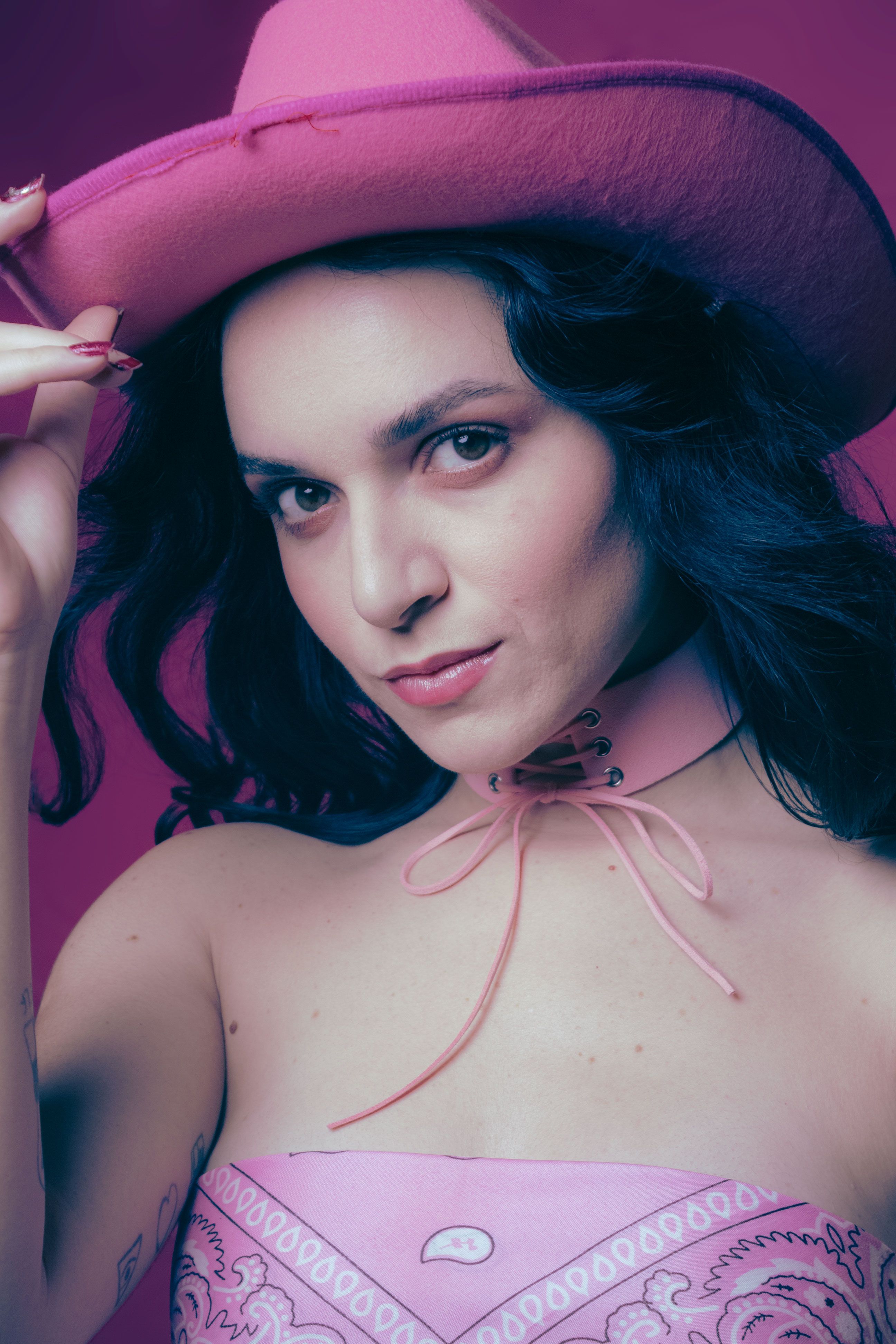 Stylish cowgirl in São Paulo wearing a pink hat and outfit, striking a confident pose.