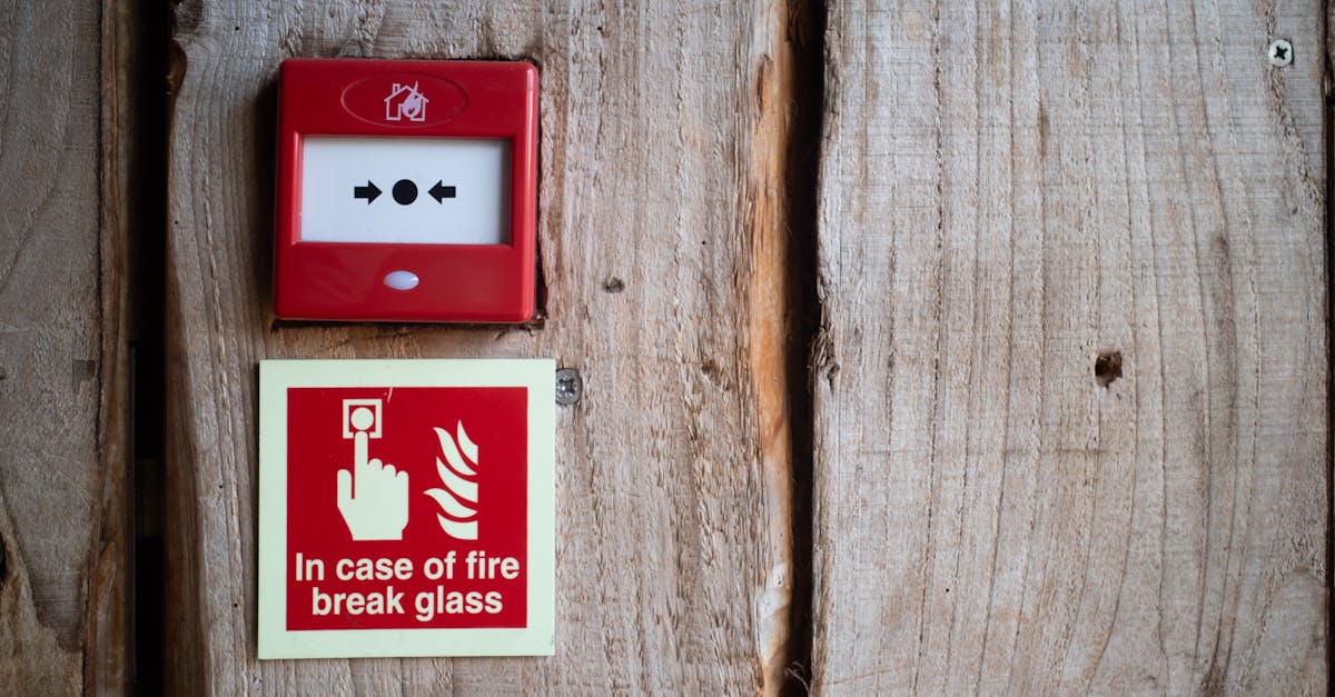 Photo by James Thomas Red fire alarm and warning sign on a rustic wooden wall for safety awareness indoors.
