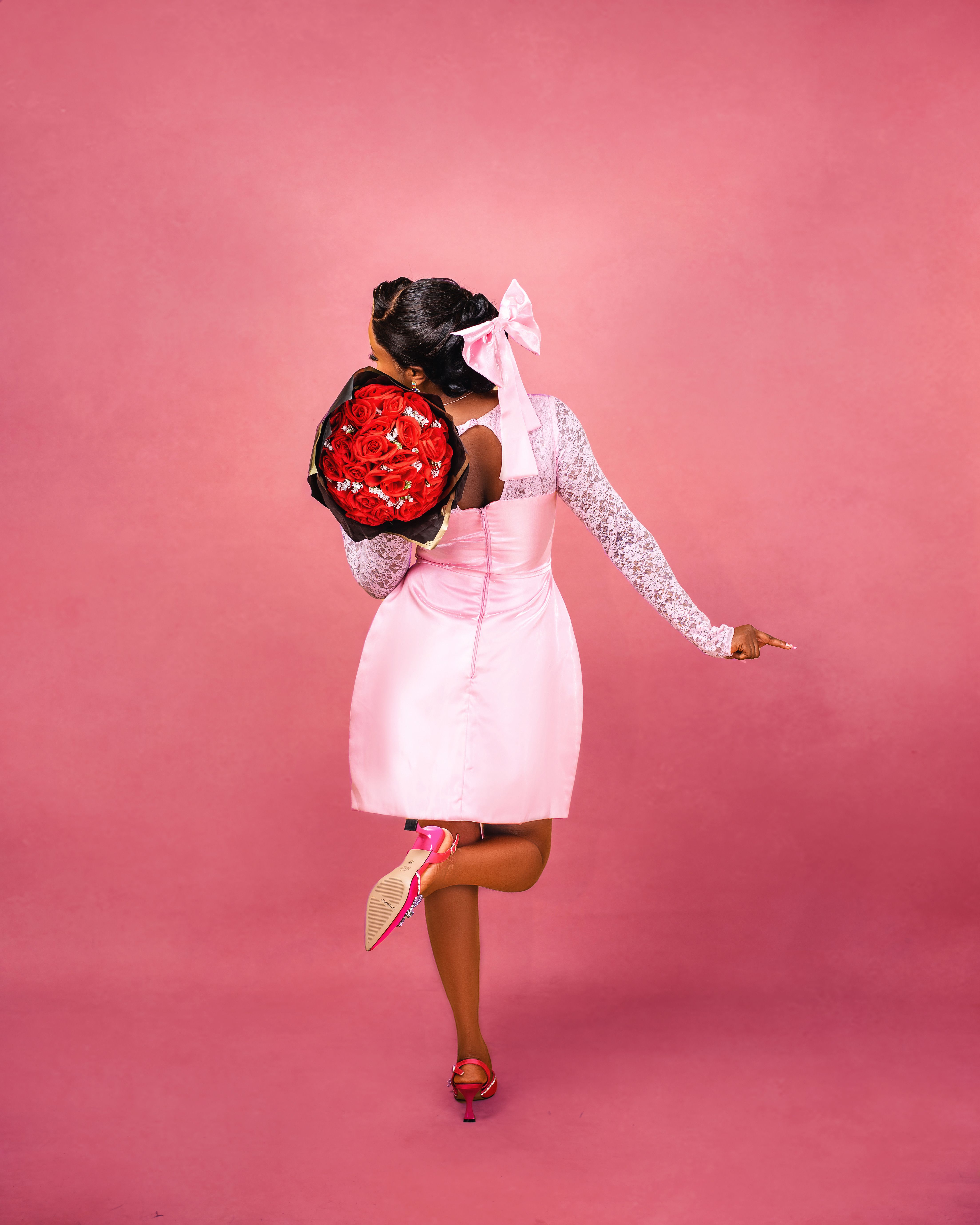 Woman in Pink Dress Holding a Bouquet of Red Roses · Free Stock Photo