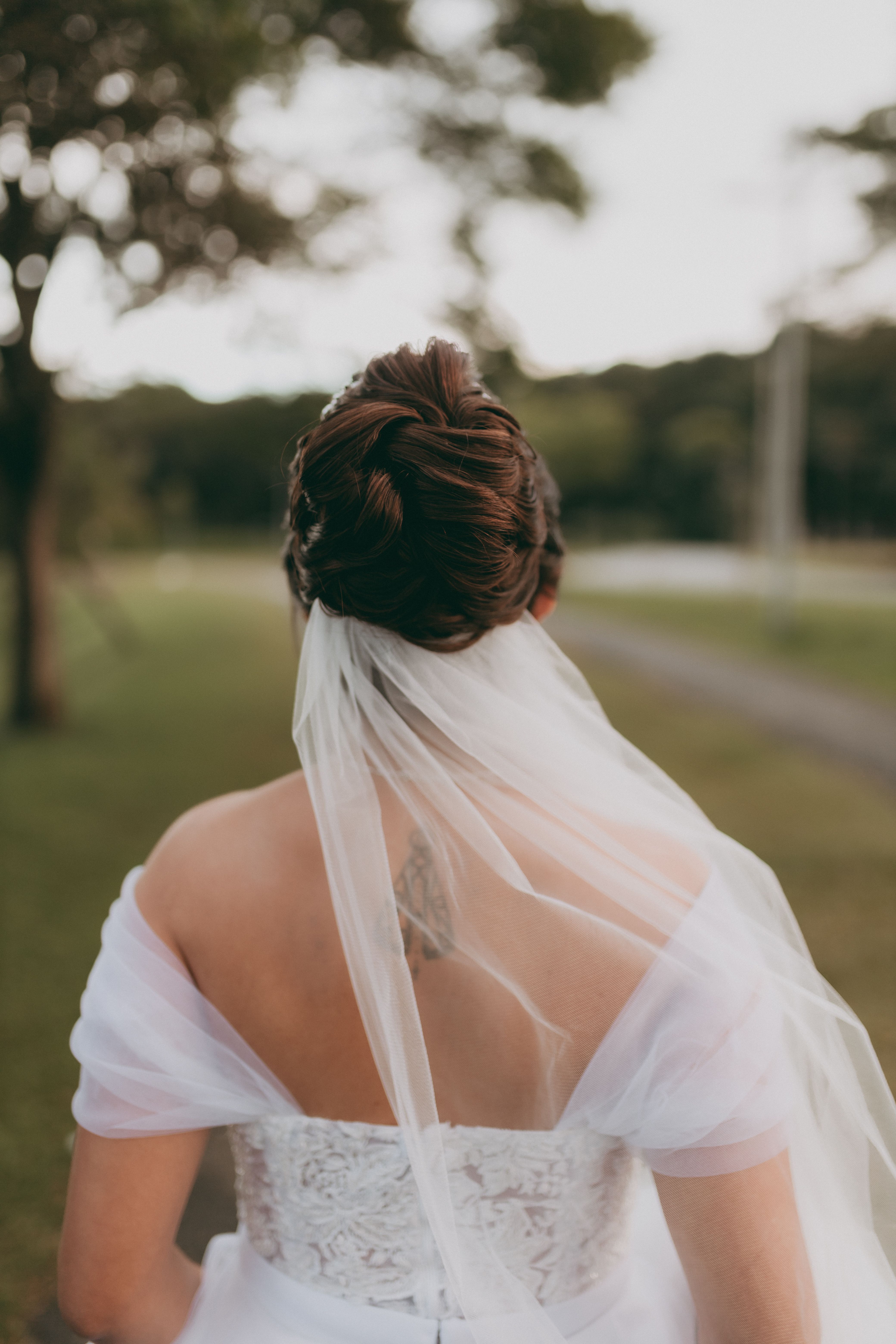 Chignon de mariée élégant vu de dos, cheveux relevés et travaillés