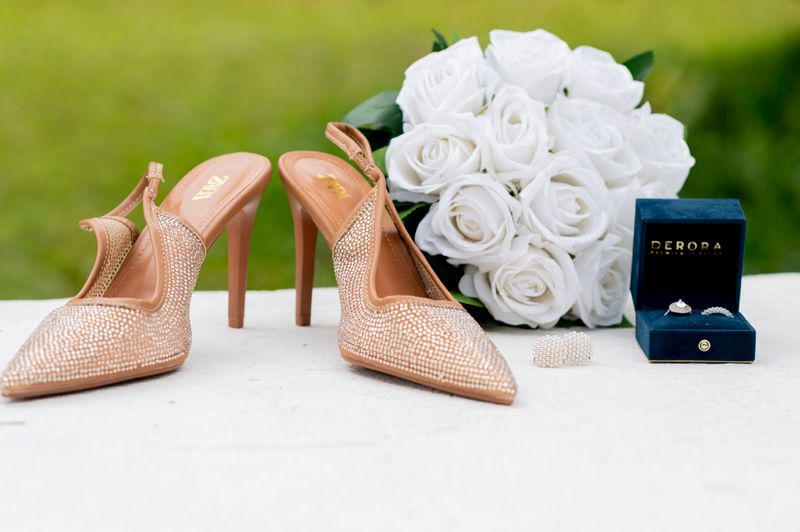 Sparkling heels with white roses and jewelry, perfect for a wedding setting.