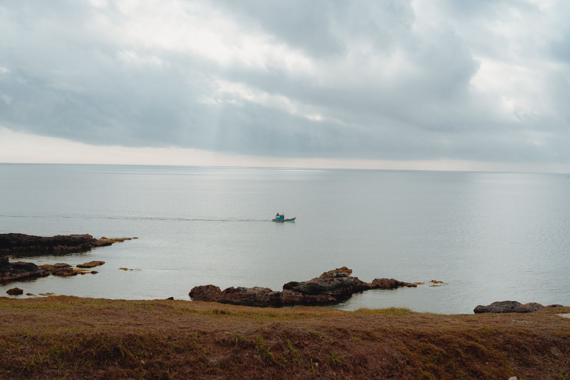 Serene coastal scene with a lone fishing boat, captured in Bình Thuận, Vietnam.