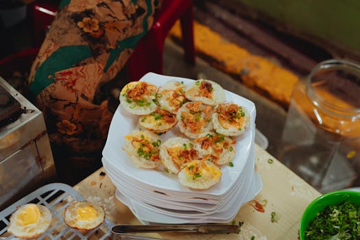 Plate of traditional bánh khọt with toppings, captured in a market setting in Bình Thuận, Vietnam.