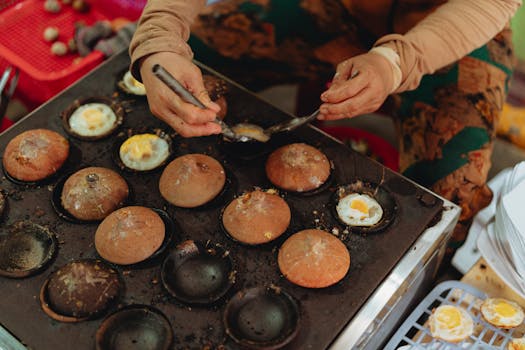A street vendor preparing traditional Vietnamese egg cakes in Bình Thuận, Vietnam.