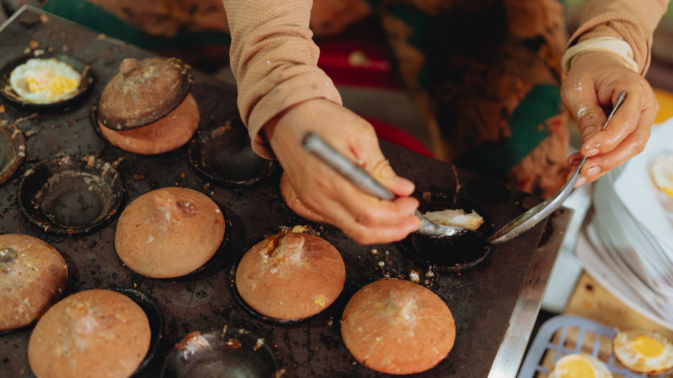 Capturing the intricate process of making Vietnamese street snacks using clay molds.