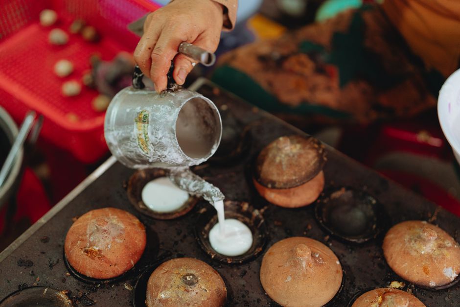 A street vendor skillfully cooks Vietnamese pancakes outdoors in Bình Thuận.