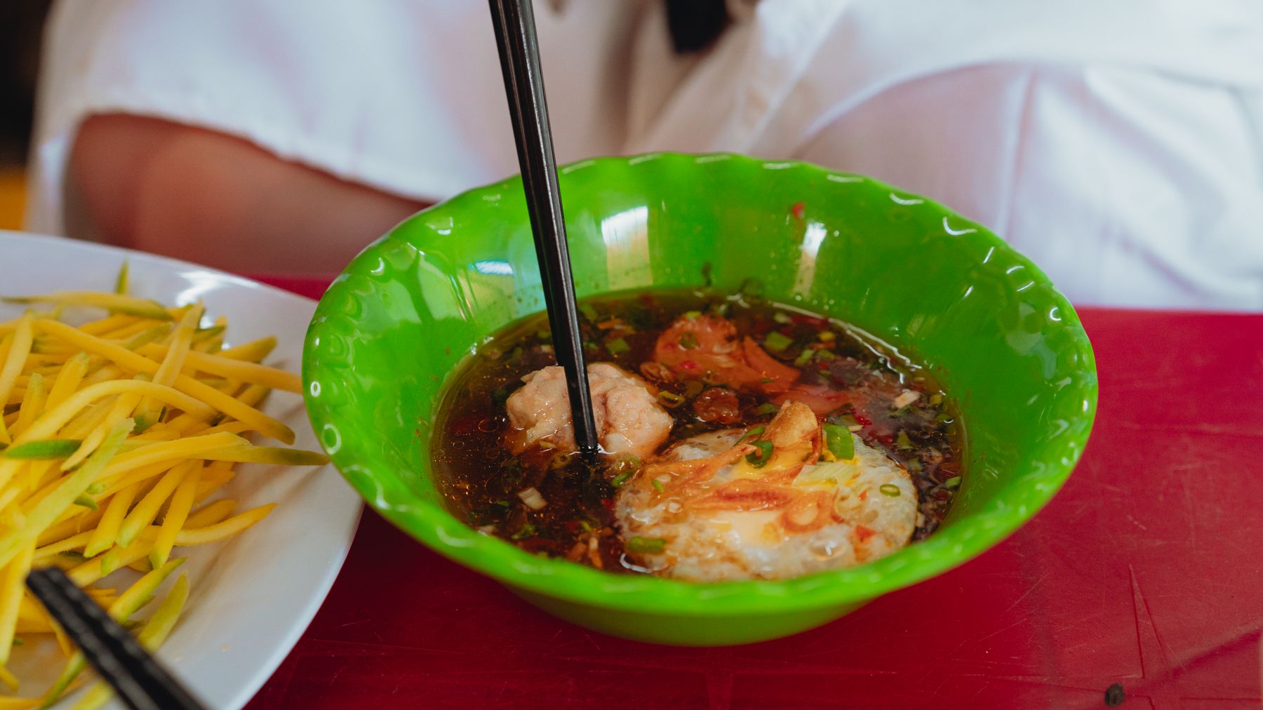 A flavorful Vietnamese soup with fresh shrimp and vegetables in a vibrant setting.
