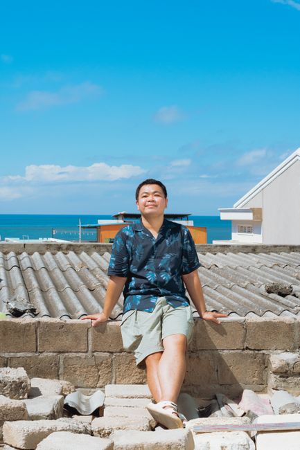 Man enjoys sunny day on rooftop overlooking the sea in Bình Thuận, Vietnam.
