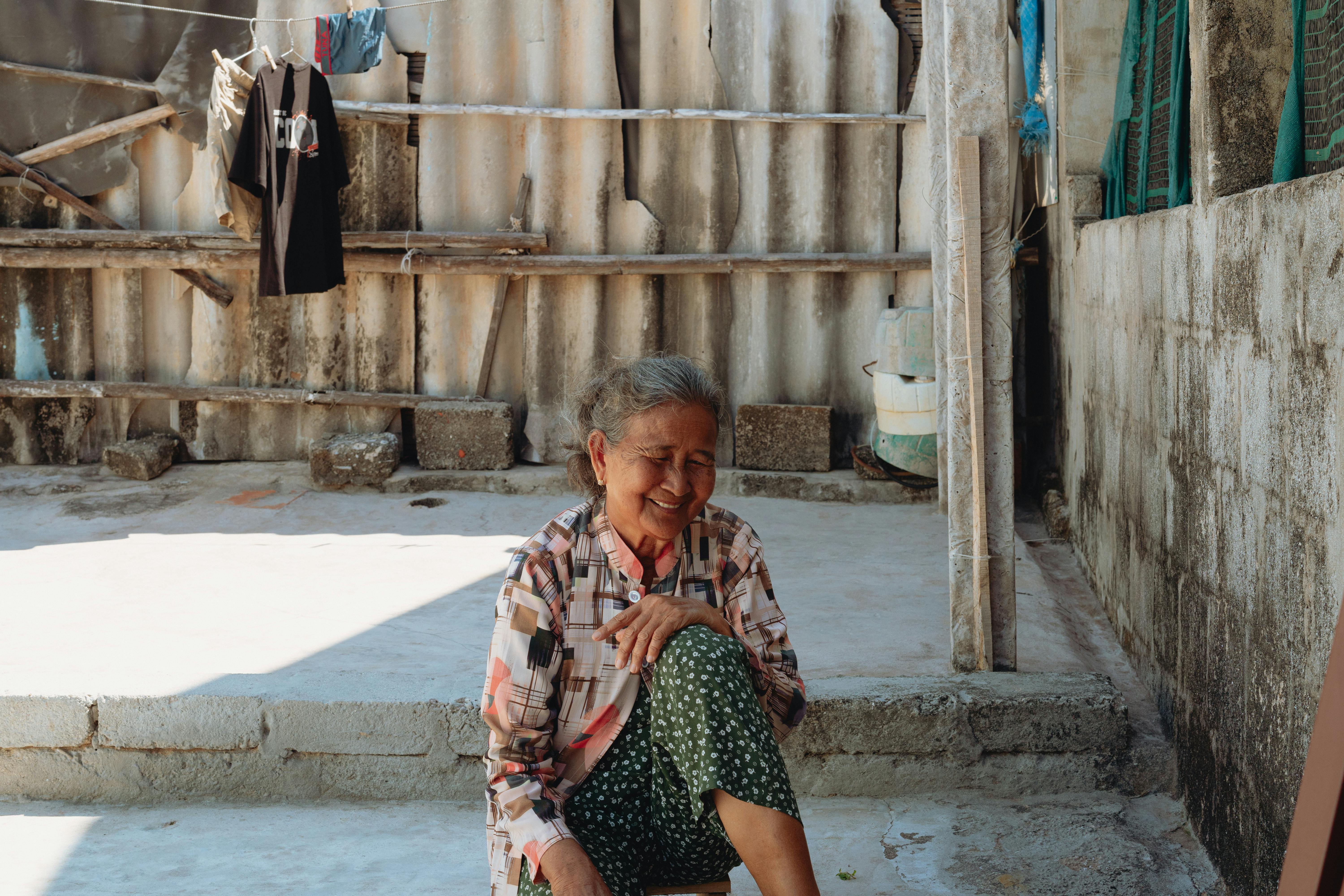 smiling elderly woman sitting outdoors in vietnam