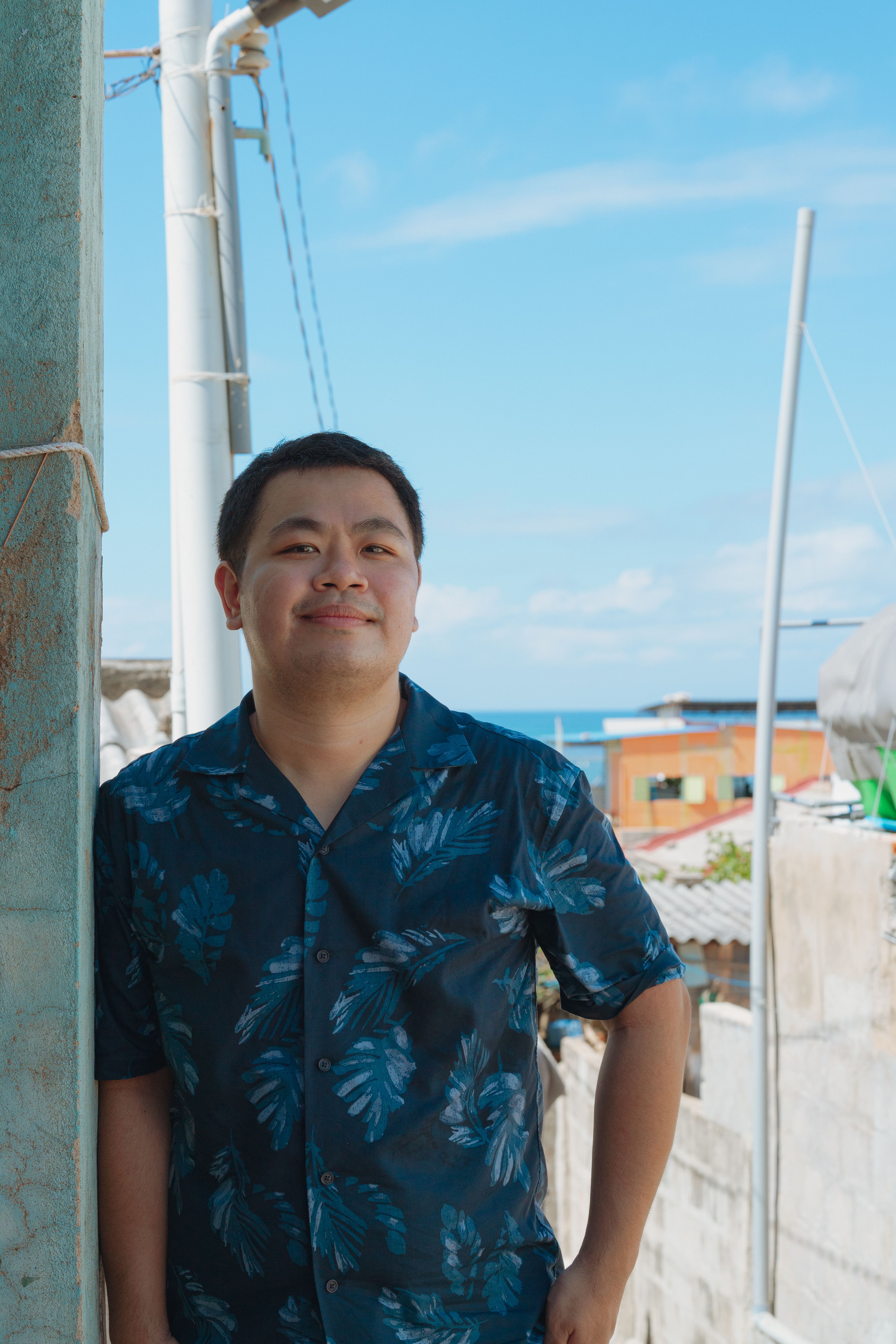 Casual portrait of a man outdoors with blue skies in Vietnam.