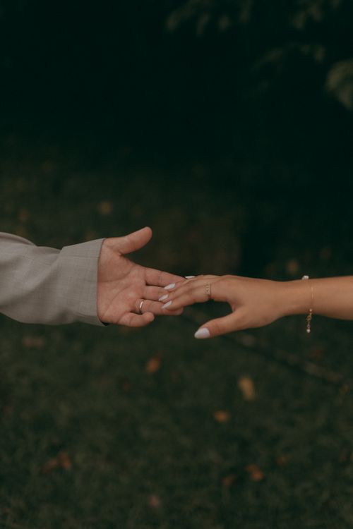 Free Close-up of two hands reaching towards each other outdoors, symbolizing connection. Stock Photo