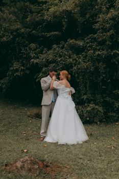 Newlywed couple shares a tender moment surrounded by nature.