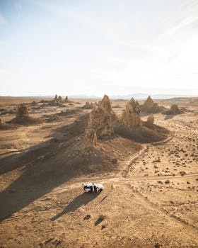 Aerial Photo of Vehicle Near Rock Formations with the Quote "Words can only have a positive effect on others if and when they are ready to listen." written on it and have average color value #B9A997