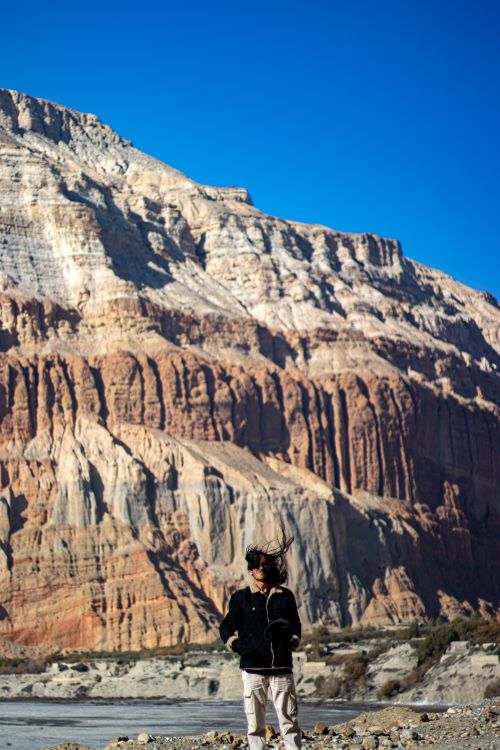 Free A woman stands in awe, viewing the stunning mountainous landscape on a clear day. Stock Photo