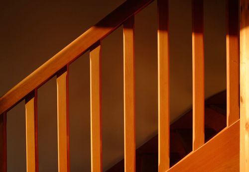 Free Wooden staircase bathed in warm light, creating a cozy ambiance. Stock Photo