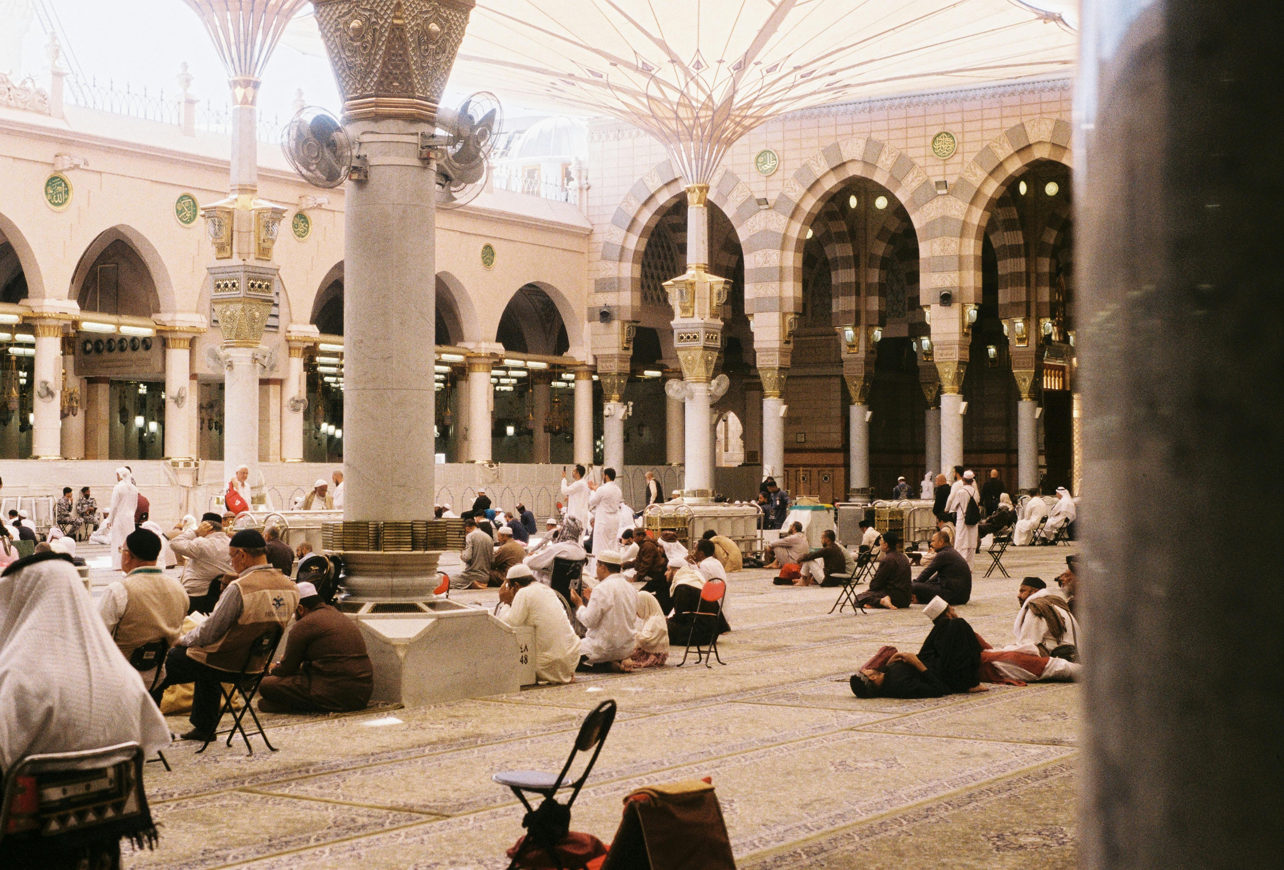 Free Pilgrims in prayer at Al-Masjid an-Nabawi, showcasing Islamic architecture. Stock Photo