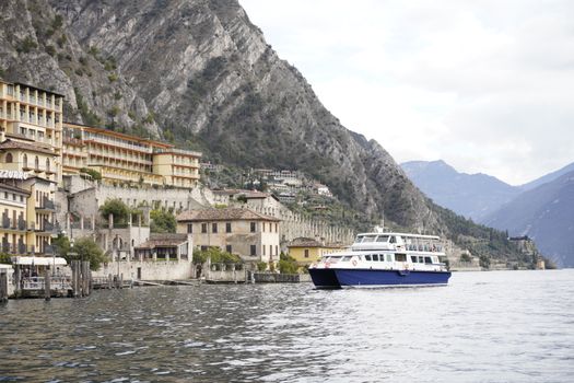 Stunning view of Limone Sul Garda with mountains, buildings, and a boat on the lake.