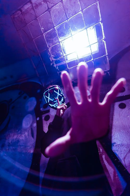 Free Low Angle Photo of Person Wearing LED Mask While Doing Silence Gesture Stock Photo
