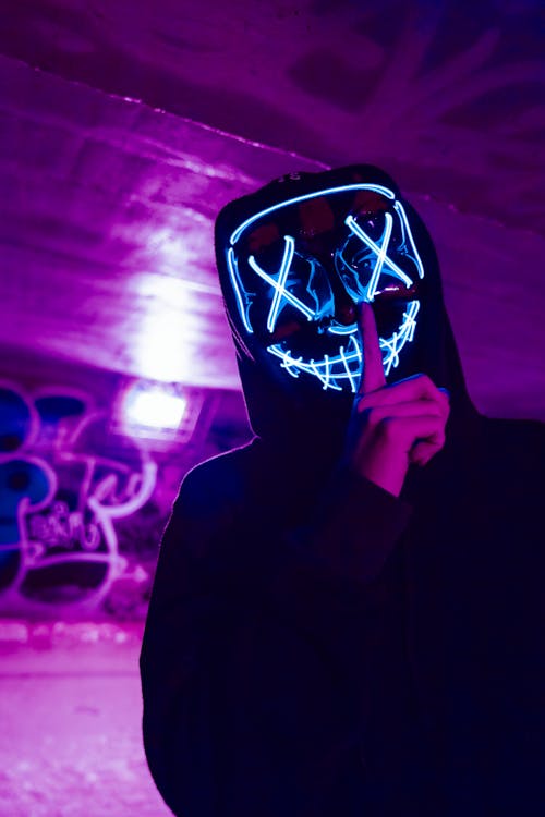 Free Person Wearing LED Mask Doing Silence Gesture Stock Photo